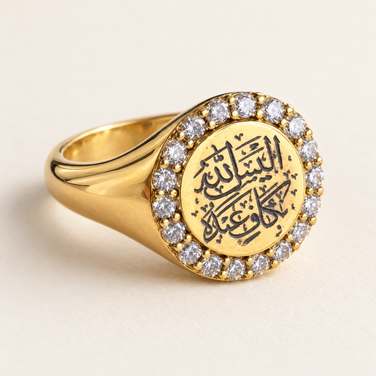Arabic calligraphy signet ring in gold-tone finish with a clear stone halo, studio view